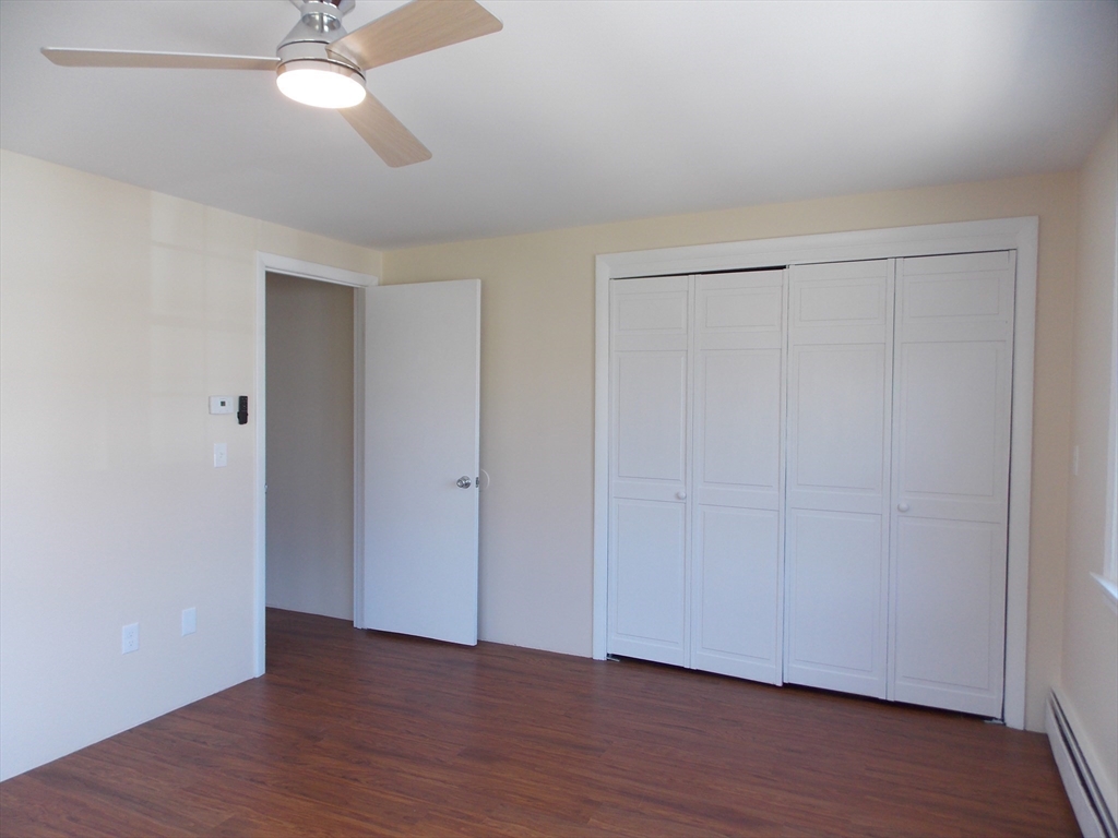 196 Main Street, Unit A Rockport, MA 01966 - Photo 17 of 36 a view of an empty room with wooden floor