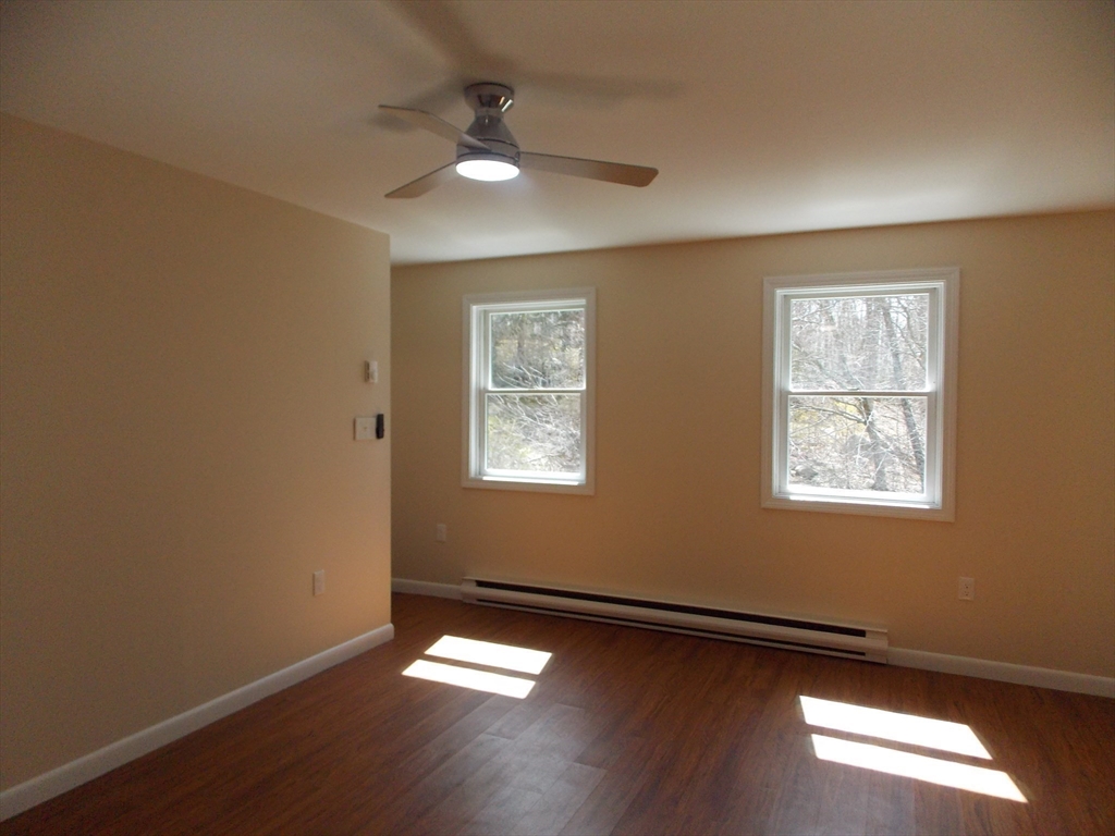 196 Main Street, Unit A Rockport, MA 01966 - Photo 20 of 36 a view of empty room with wooden floor and fan