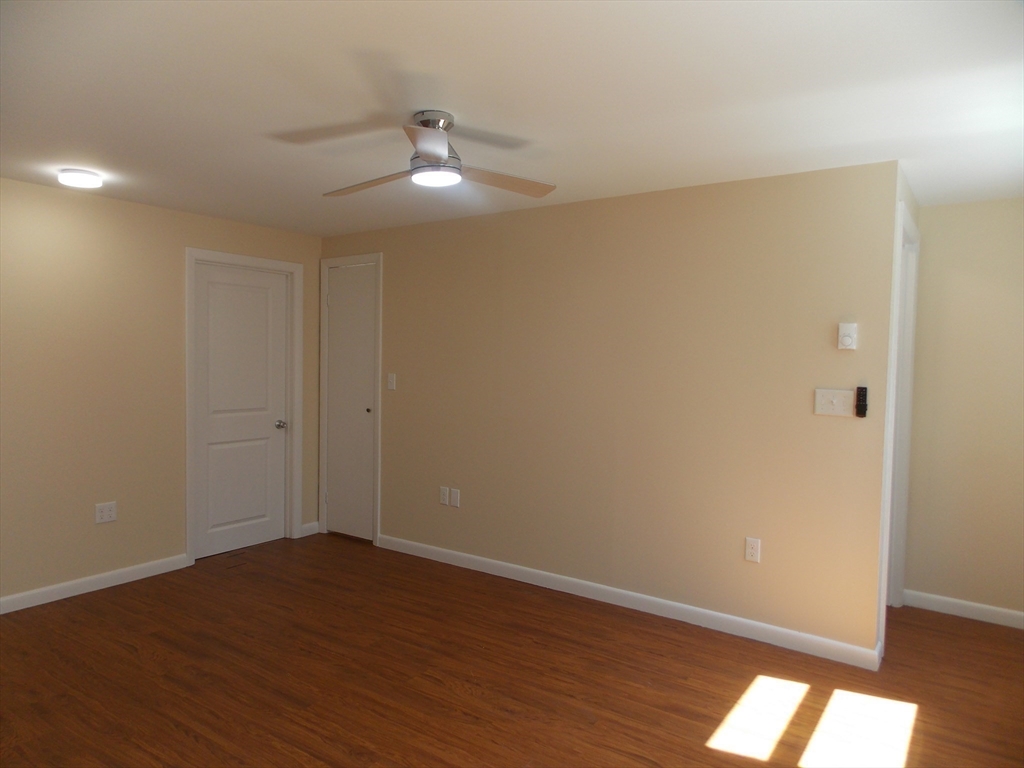 196 Main Street, Unit A Rockport, MA 01966 - Photo 21 of 36 a view of an empty room with wooden floor