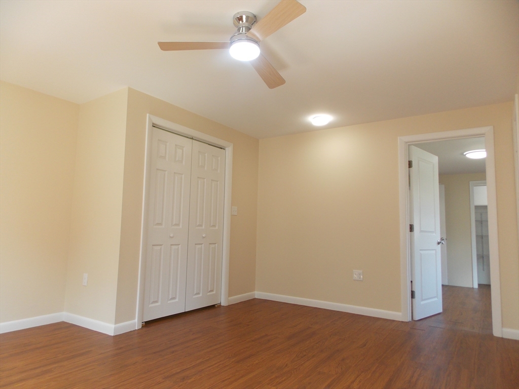 196 Main Street, Unit A Rockport, MA 01966 - Photo 22 of 36 a view of an empty room with wooden floor