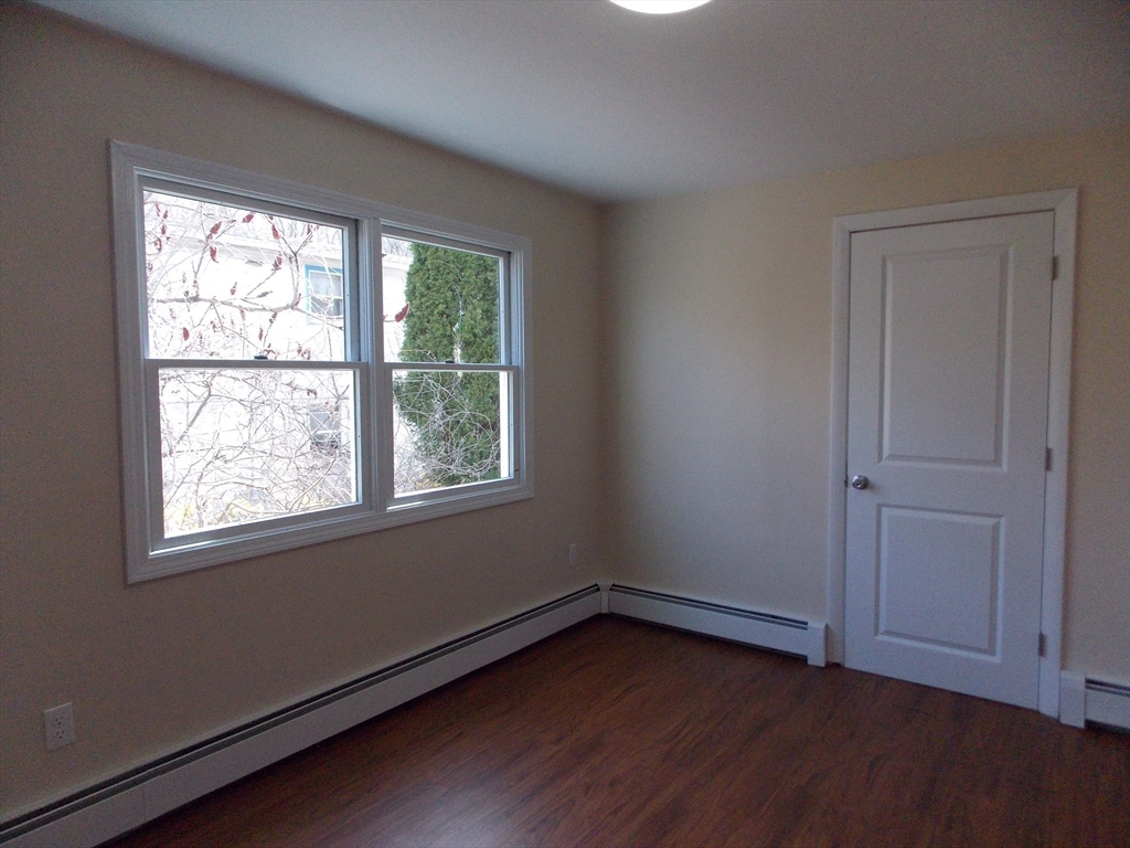 196 Main Street, Unit A Rockport, MA 01966 - Photo 24 of 36 a view of an empty room with wooden floor and a window