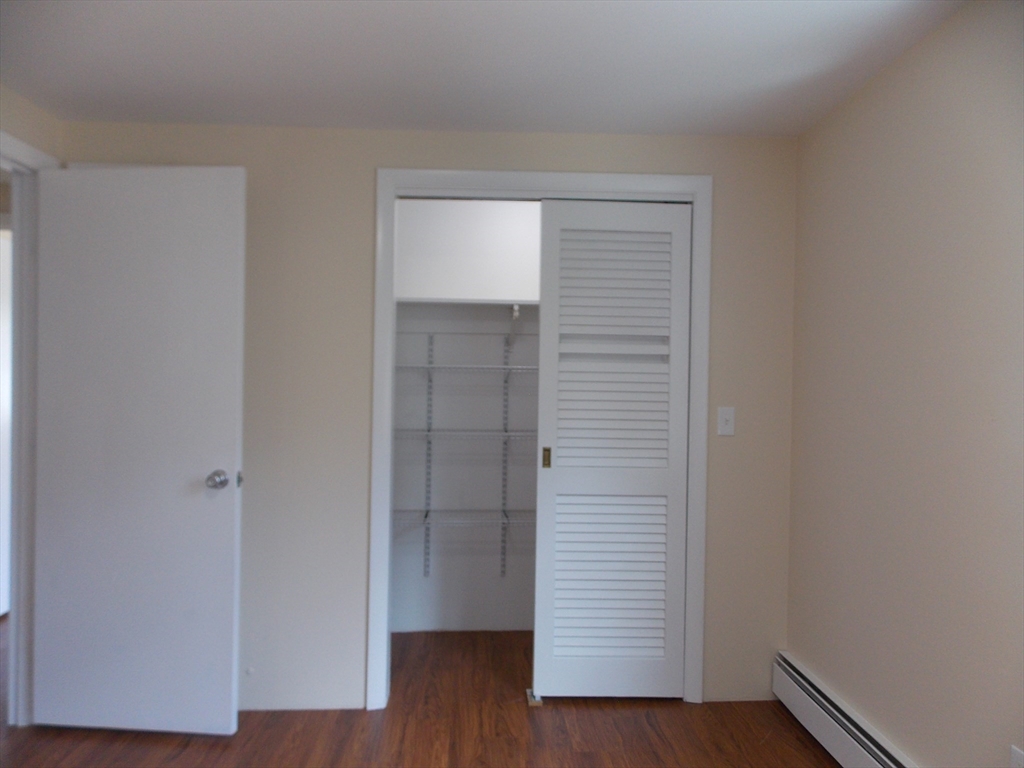 196 Main Street, Unit A Rockport, MA 01966 - Photo 25 of 36 a view of an empty room with wooden floor