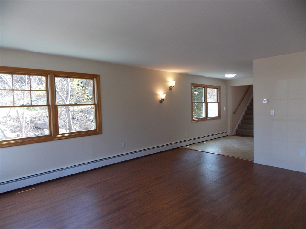 196 Main Street, Unit A Rockport, MA 01966 - Photo 4 of 36 a view of an empty room with wooden floor and windows