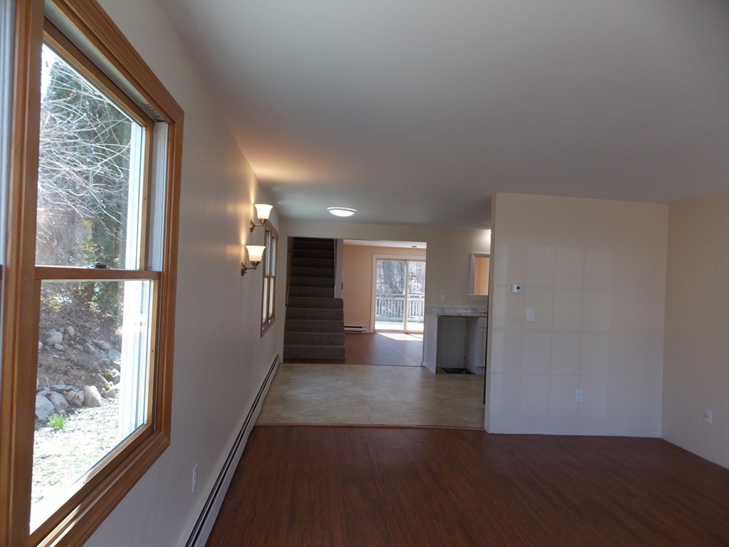 196 Main Street, Unit A Rockport, MA 01966 - Photo 5 of 36 a view of empty room with wooden floor and fan