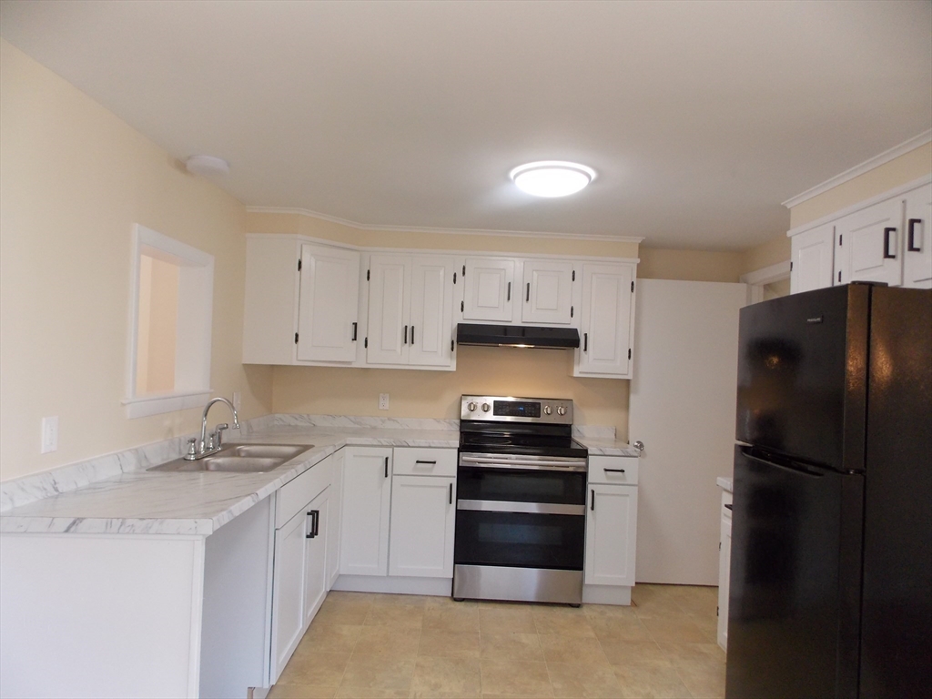 196 Main Street, Unit A Rockport, MA 01966 - Photo 7 of 36 a kitchen with stainless steel appliances a refrigerator stove and sink