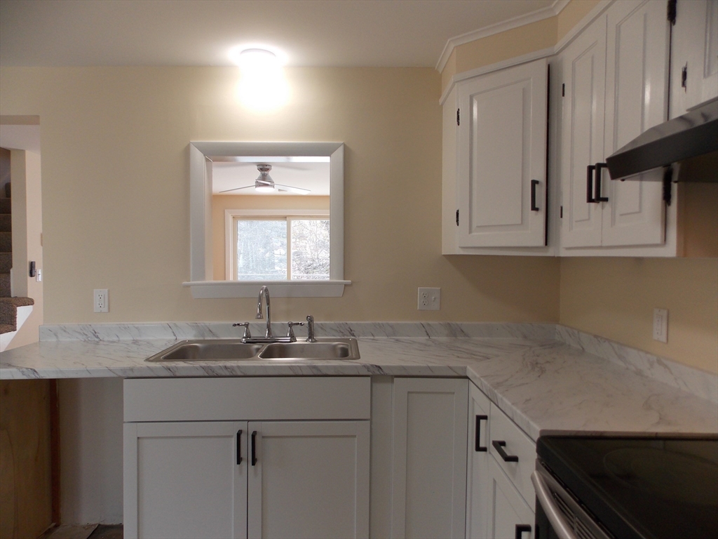 196 Main Street, Unit A Rockport, MA 01966 - Photo 9 of 36 a kitchen with a sink cabinets and window