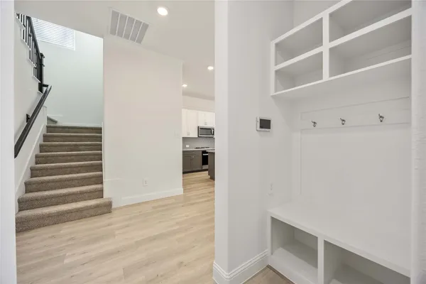 a view of a hallway with wooden floor and entryway