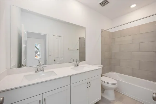 a bathroom with a double vanity sink toilet and shower