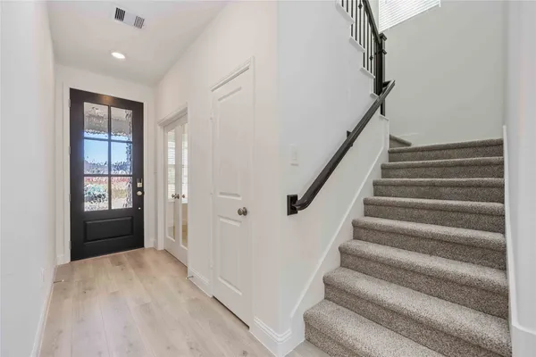 a view of entryway with wooden floor and stairs
