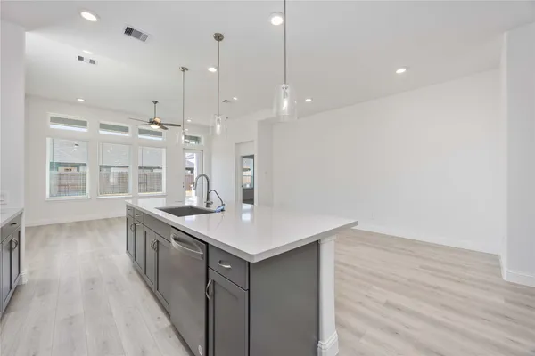 a kitchen with a sink a large window and wooden floor