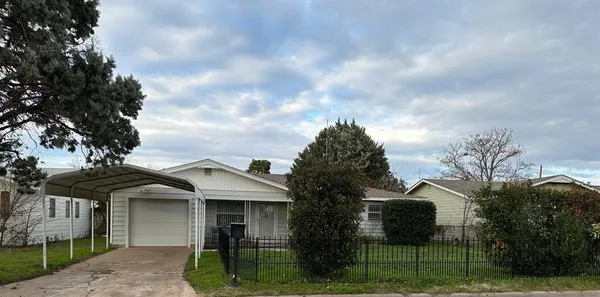 a front view of a house with a garden and trees