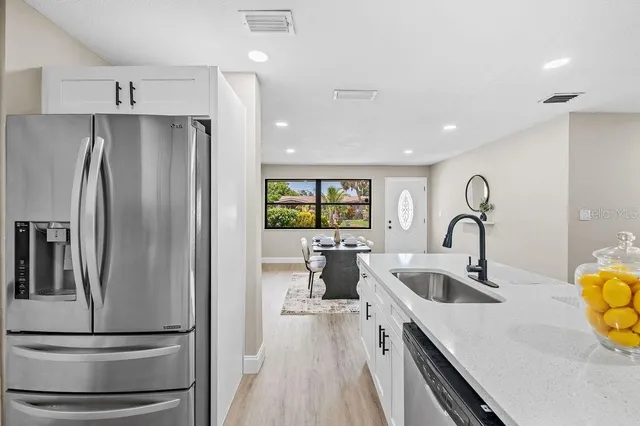 a kitchen with stainless steel appliances granite countertop a refrigerator and a sink