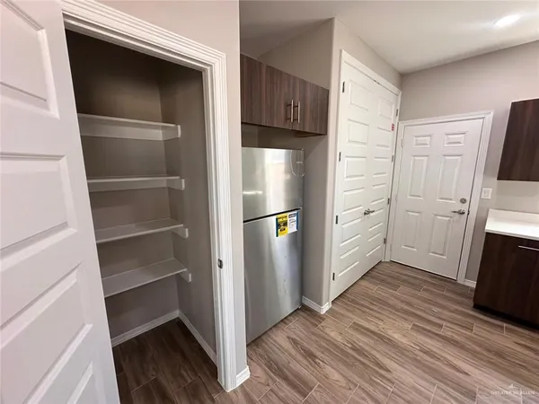 a view of a kitchen with a sink and a refrigerator