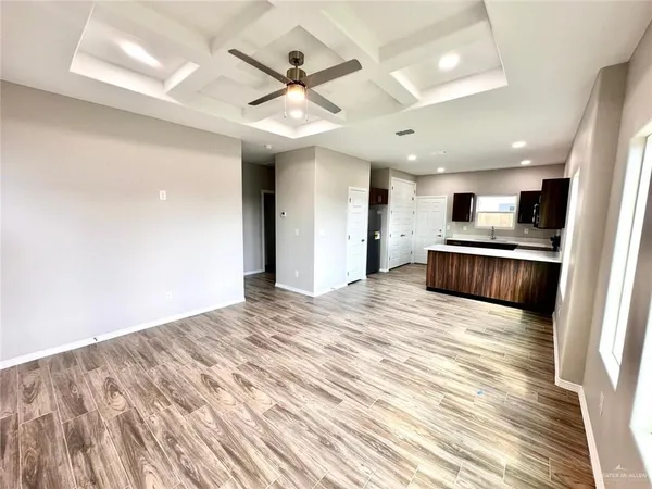 a view of a hallway with wooden floor and closet