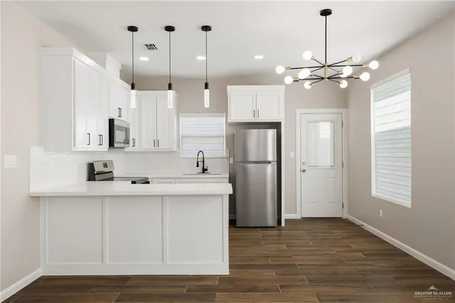 a kitchen with kitchen island a sink stainless steel appliances and cabinets