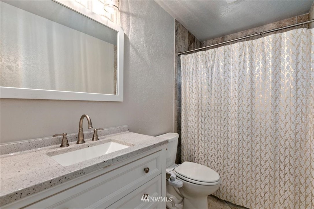 409 176th Place Southwest Bothell, WA 98012 - Photo 22 of 36 a bathroom with a granite countertop sink and a toilet