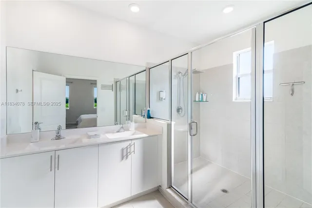 a bathroom with a shower sink and mirror