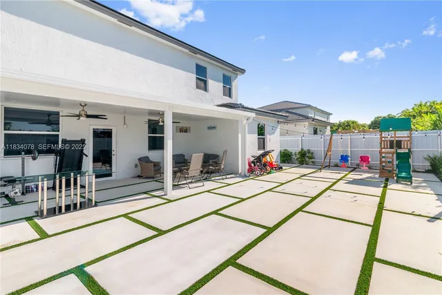 a view of a patio with a table and chairs under an umbrella