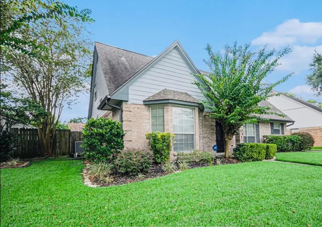 a front view of house with a garden