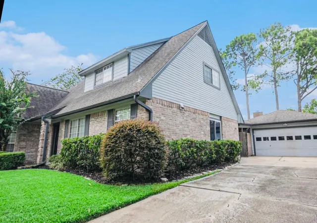 a view of a house with a yard and potted plants