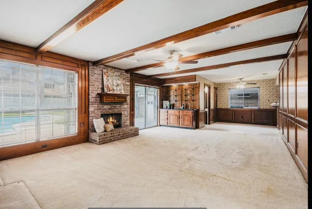 a view of an empty room with a fireplace and a window