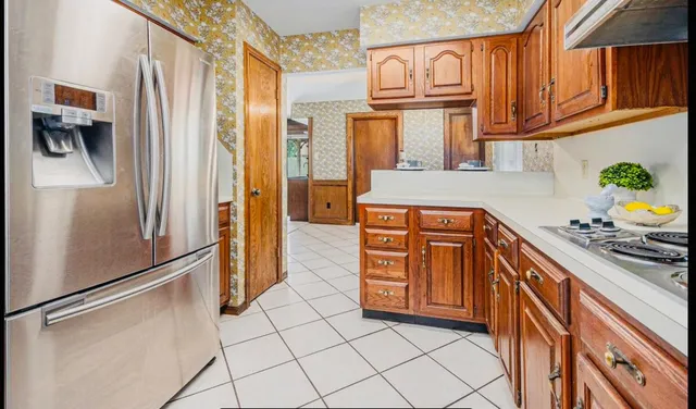a kitchen with stainless steel appliances granite countertop a refrigerator and a sink