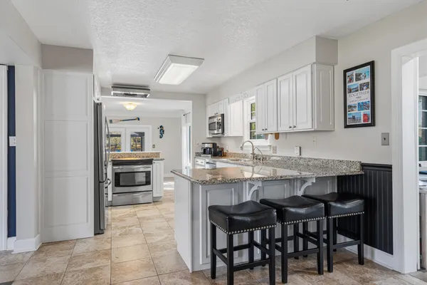 a kitchen with stainless steel appliances granite countertop a sink a stove and microwave
