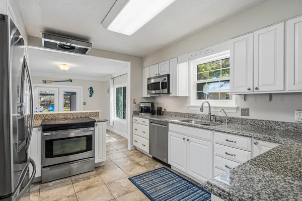 a kitchen with stainless steel appliances granite countertop a refrigerator and a sink