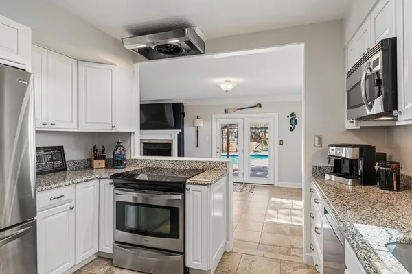 a view of a kitchen with wooden floor and a ceiling fan