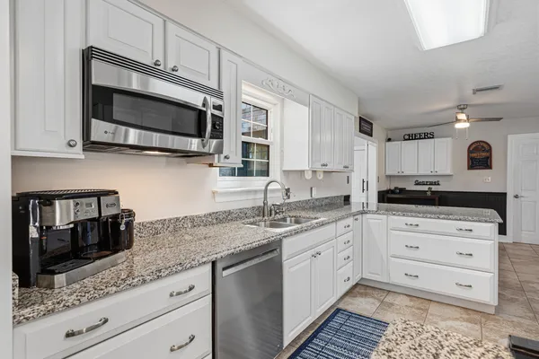 a view of a hallway with entryway wooden floor and windows