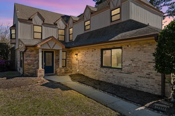 a view of a white house with a yard and large tree