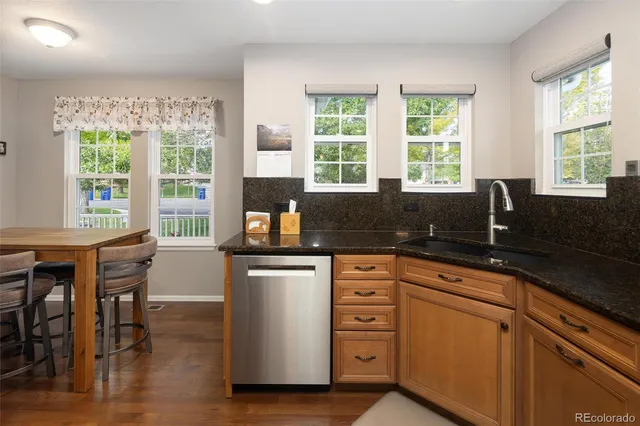a kitchen with granite countertop a sink and white cabinets
