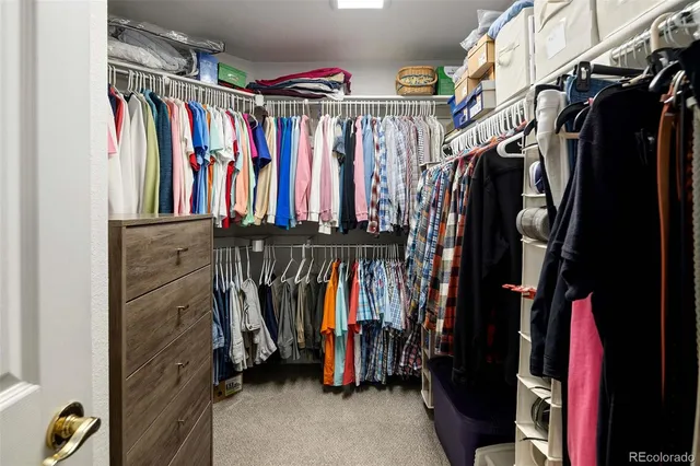 a view of walk in closet with clothes and shoes