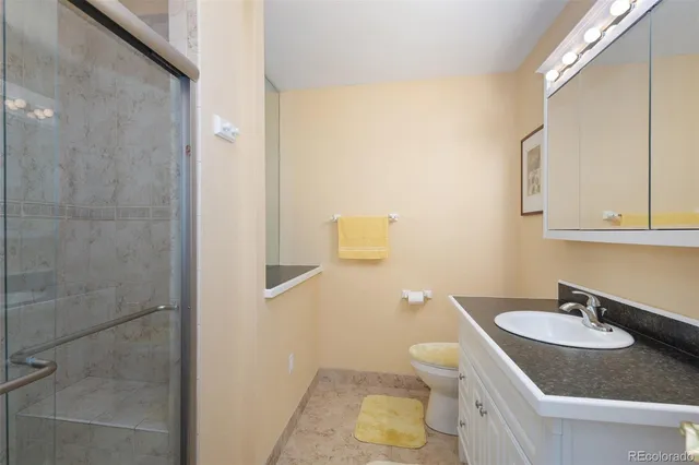 a bathroom with a granite countertop sink and a mirror with toilet