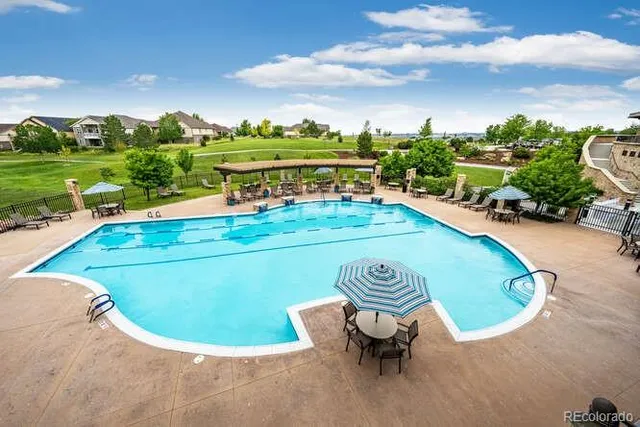 a view of a swimming pool with a yard and outdoor seating