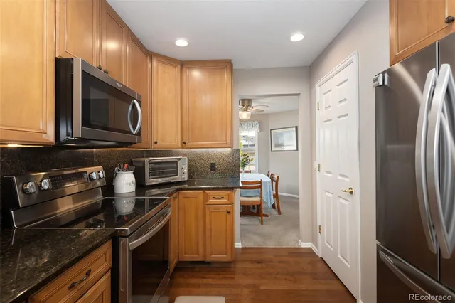 a kitchen with stainless steel appliances granite countertop a refrigerator a stove a sink and a microwave