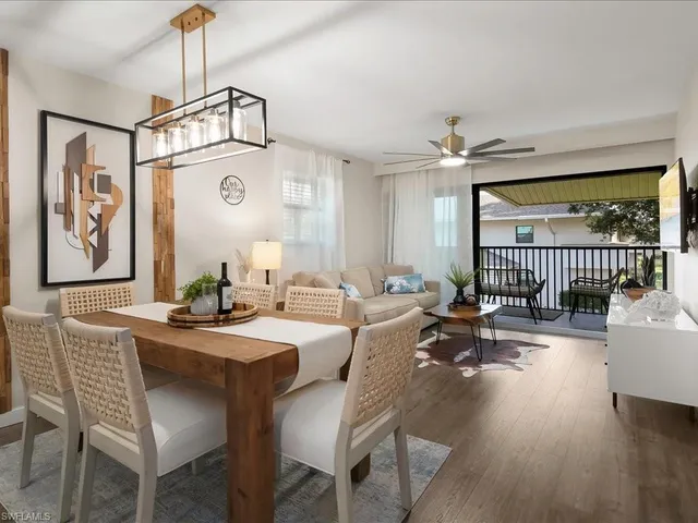 a dining room with wooden floor a chandelier a wooden table and chairs