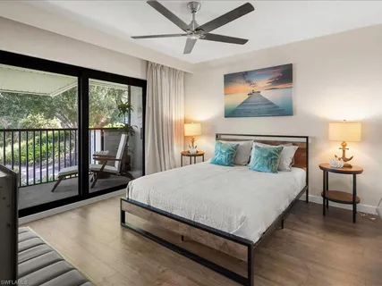 a large bedroom with a bed and wooden floor