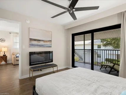 a bedroom with a bed a television and a large window