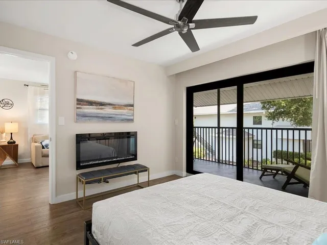 a bedroom with a bed a television and a large window