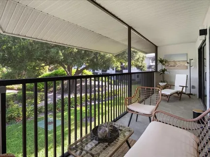 a view of a porch with furniture and wooden floor