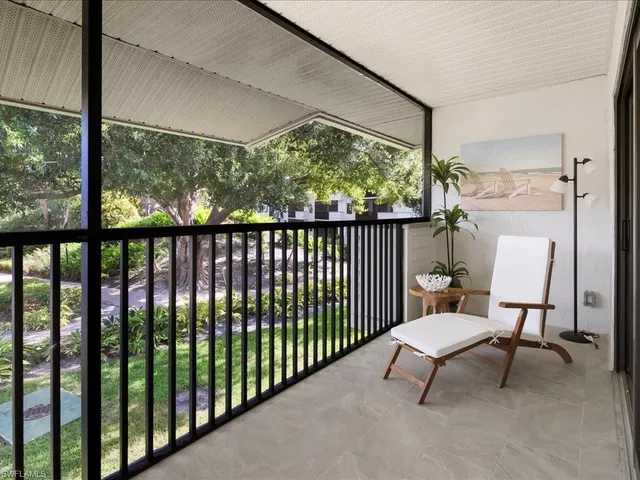 a view of a porch with furniture and a yard