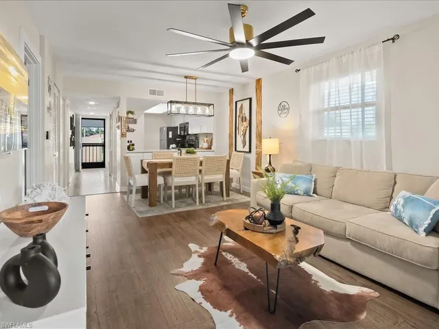 a living room with furniture a wooden floor and a chandelier