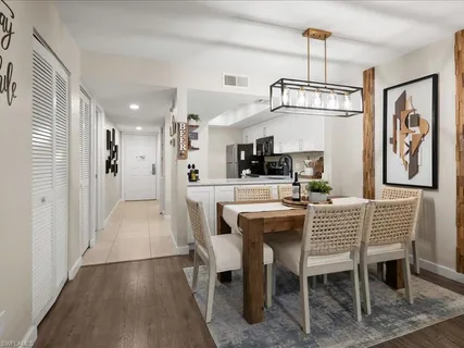 a dining room with furniture a chandelier and wooden floor