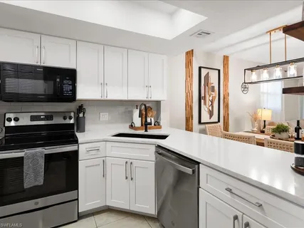 a kitchen with granite countertop a sink stainless steel appliances and cabinets