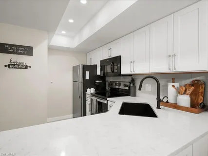 a kitchen with stainless steel appliances a refrigerator a sink a stove top oven a counter space and cabinets