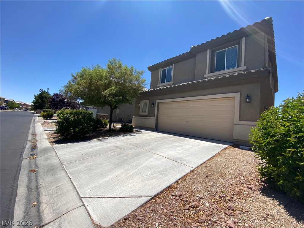 489 Foster Springs Road Las Vegas, NV 89148 - Photo 1 of 30 A well-maintained concrete driveway leads to a two-story home with an attached garage.
