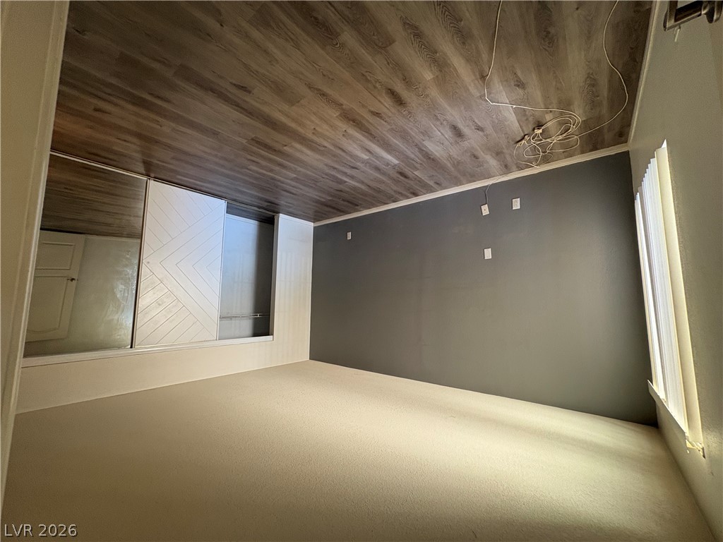 9325 West Desert Inn Road, Unit 123 Las Vegas, NV 89117 - Photo 22 of 36 A well-lit bedroom features plush carpeting, a modern sliding closet, and durable plank-style ceiling.