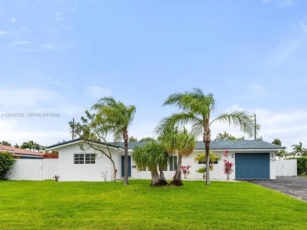 a view of a house with a yard and potted plants