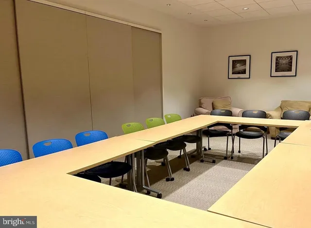 a living room with couches and a pool table with kitchen view
